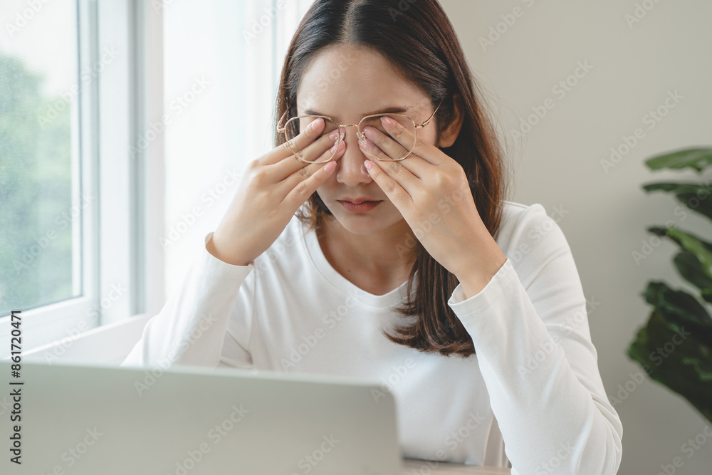 Eye problem concept, fatigue asian young woman tired eyes, irritated rubbing eye dry relief vision pain after work on laptop computer, eye strain, hand holding glasses, suffer migraine, bad blurry Eye problem concept, fatigue asian young woman tired eyes, irritated rubbing eye dry relief vision pain after work on laptop computer, eye strain, hand holding glasses, suffer migraine, bad blurry