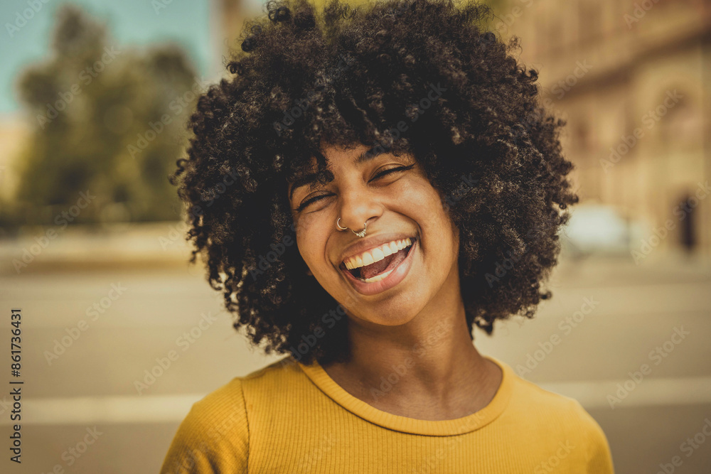 Smiling african woman smiling at camera outdoors - Portrait picture of curly afro american female laughing outside - Happy people life style concept Smiling african woman smiling at camera outdoors - Portrait picture of curly afro american female laughing outside - Happy people life style concept