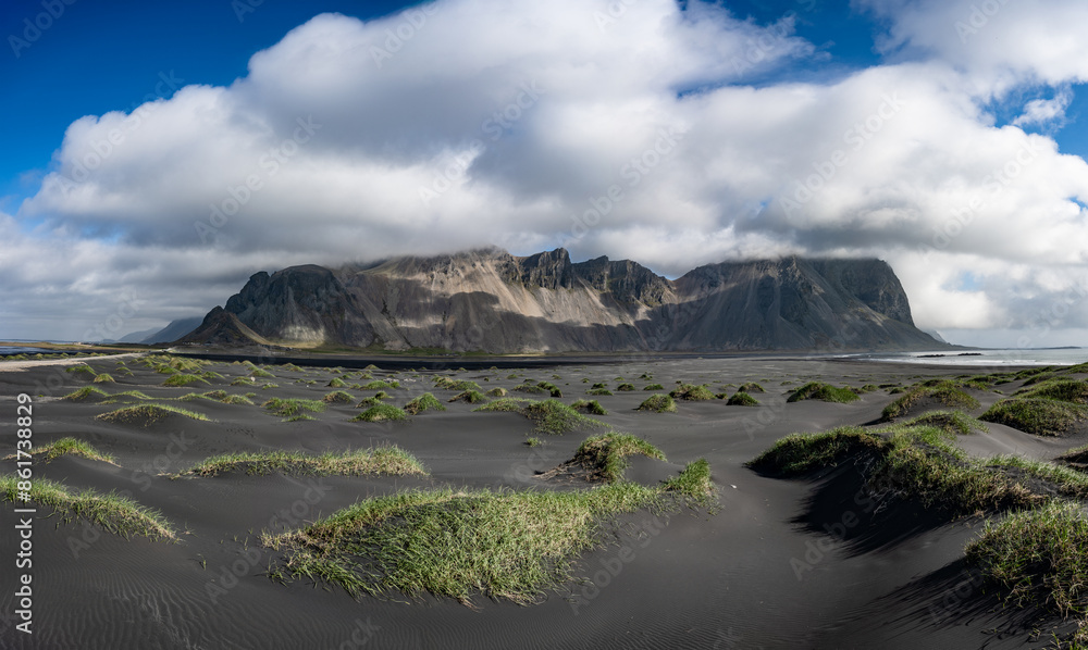 Stunning panoramic view of Vestrahorn, an impressive 454 metres tall mountain. It faces out to the sea on its southern side and is surrounded by a black sandy coastline. Iceland.