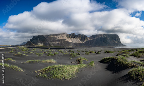 Obraz na płótnie Stunning panoramic view of Vestrahorn, an impressive 454 metres tall mountain. It faces out to the sea on its southern side and is surrounded by a black sandy coastline. Iceland. w salonie