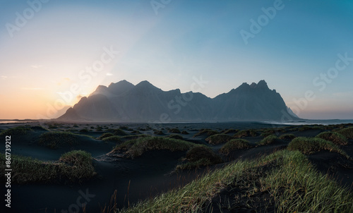 Obraz na płótnie Stunning panoramic view of Vestrahorn, an impressive 454 metres tall mountain. It faces out to the sea on its southern side and is surrounded by a black sandy coastline. Iceland. w salonie
