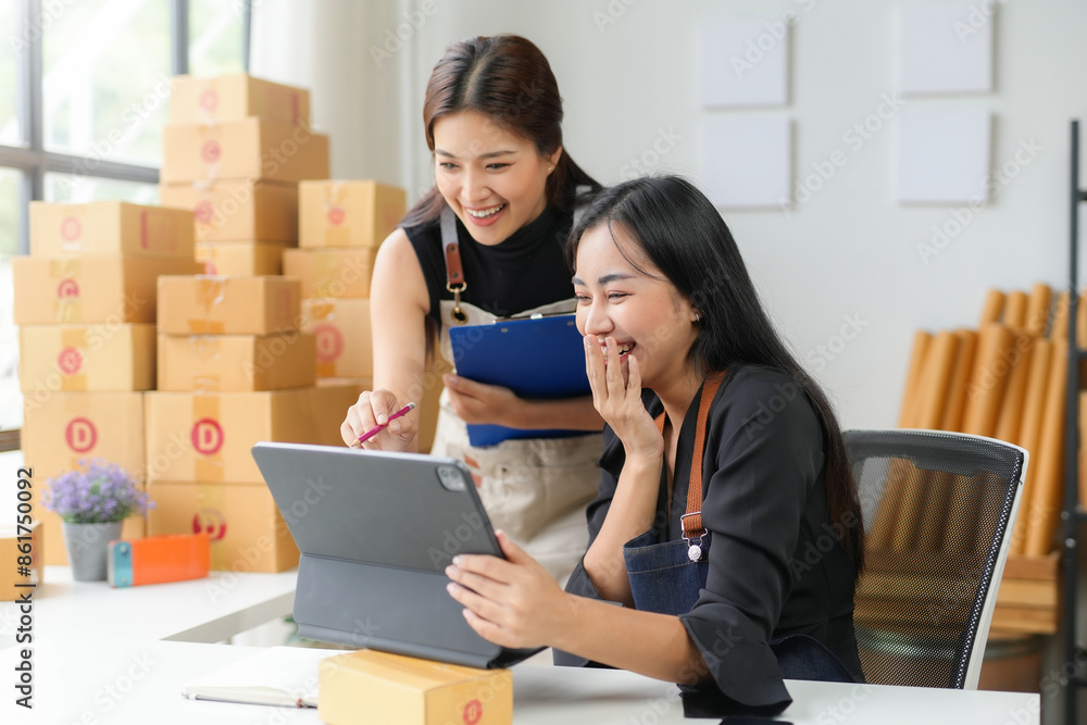 Two young businesswomen working in warehouse and using digital tablet Two young businesswomen working in warehouse and using digital tablet