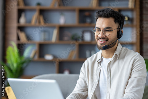 Wall Mural Smiling customer service representative working remotely with headset and laptop