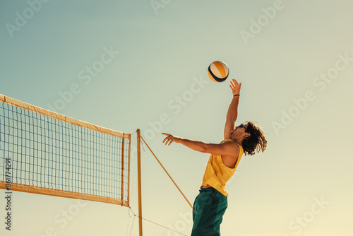 Pro beach volleyball player spiking ball mid air in championship match