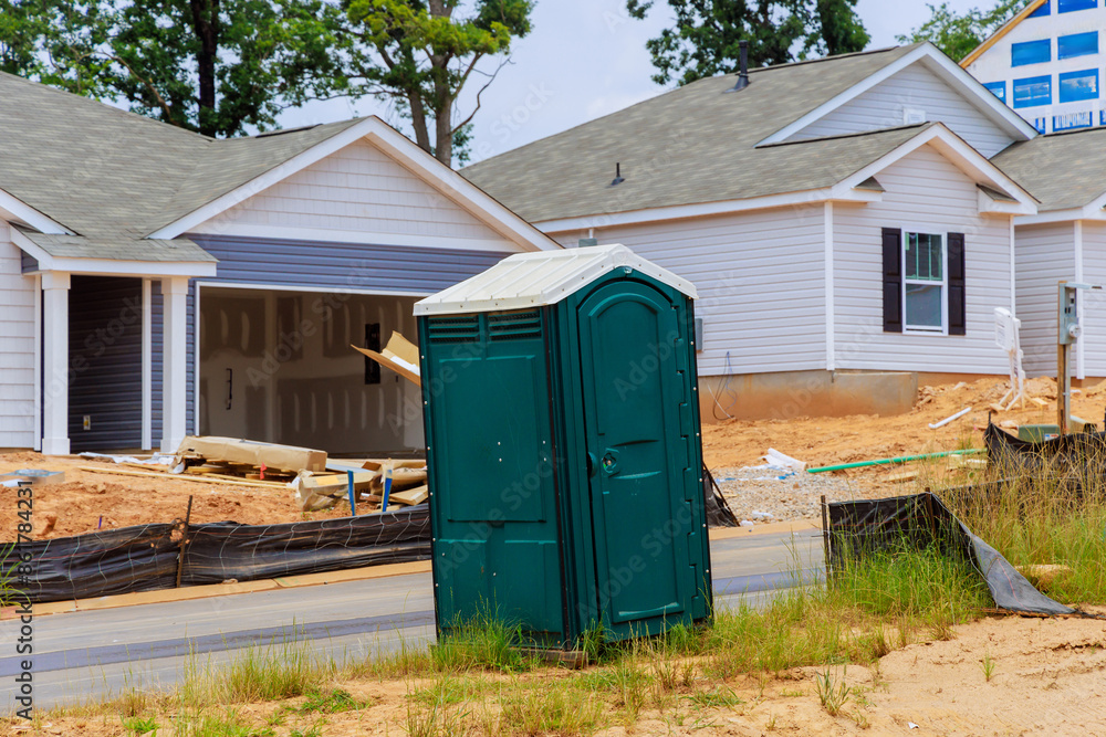 During construction of house, portable plastic bio toilet cabins stalls are located on construction site During construction of house, portable plastic bio toilet cabins stalls are located on construction site