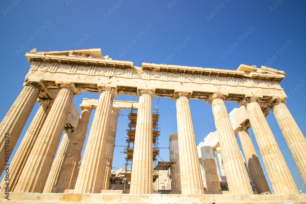 Obraz premium Ancient Parthenon Temple on top of the Acropolis Athens, Greece at sunny day with a blue sky. The landmark of Athens. Parthenon is the temple of for dedication to the goddess Athena.