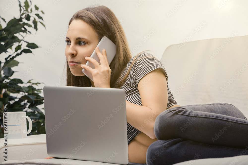 Fototapeta premium Young woman working from home having difficult phone call
