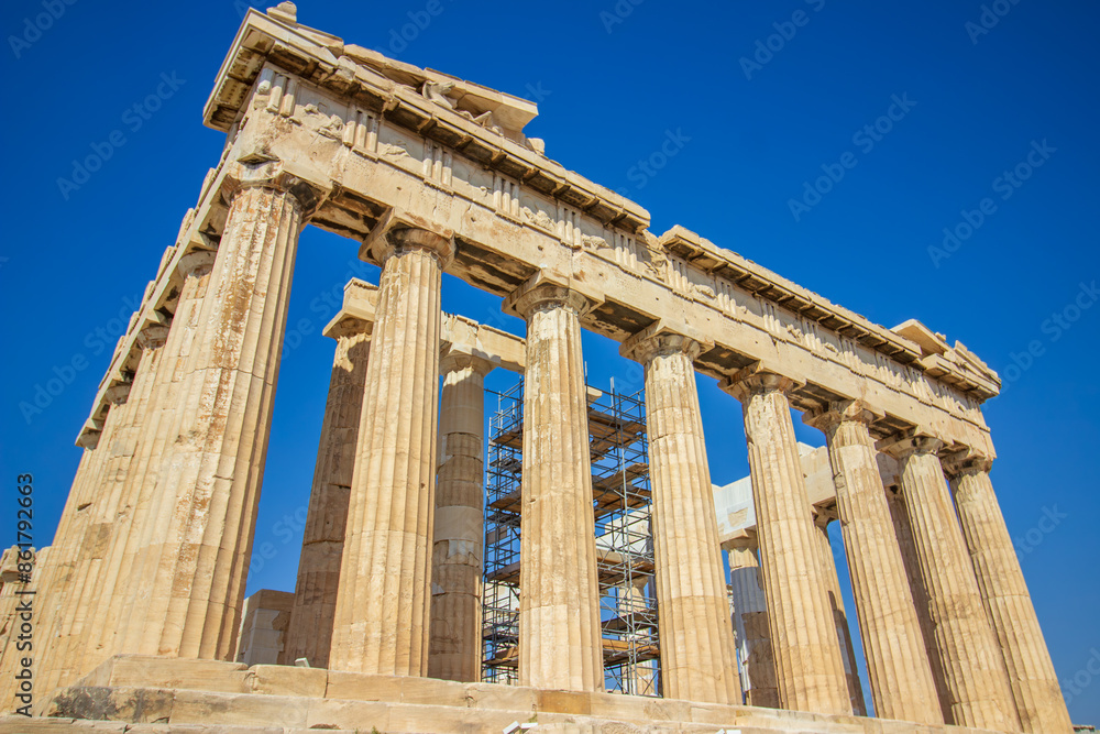 Fototapeta premium Ancient Parthenon Temple on top of the Acropolis Athens, Greece at sunny day with a blue sky. The landmark of Athens. Parthenon is the temple of for dedication to the goddess Athena.