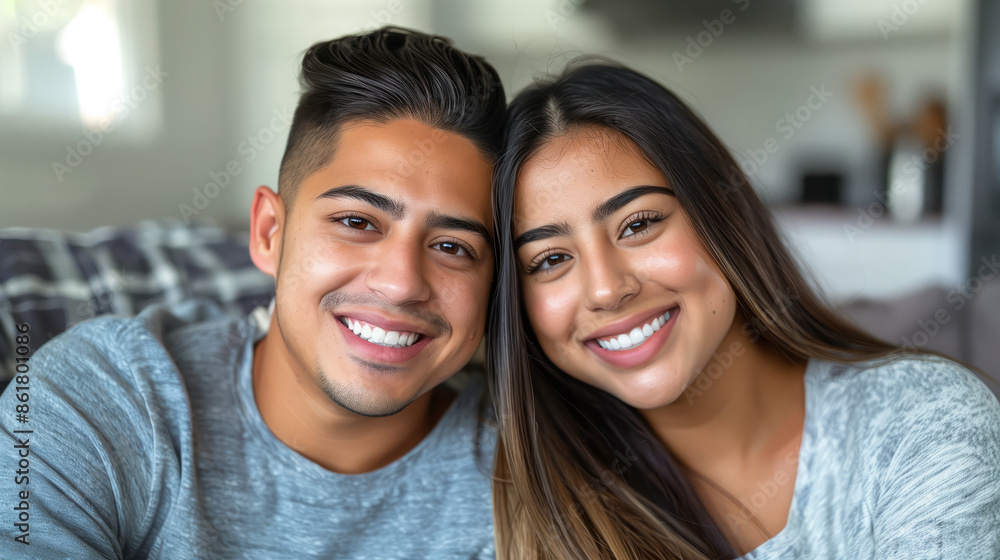 A loving couple embracing on a sofa in their living room at home. A loving couple embracing on a sofa in their living room at home.