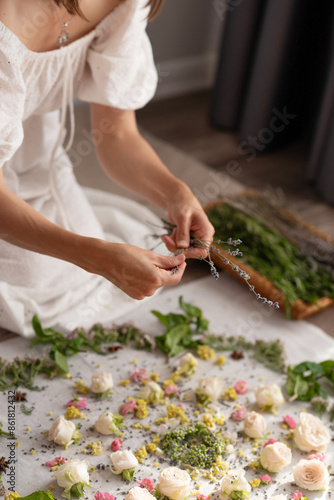 The girl collects a mandala from dried flowers and fresh flowers, symbolizing the world, the universe. Buddhism, Hinduism
