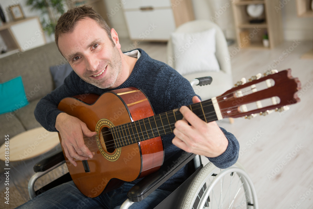Obraz premium happy handicapped man playing an acoustic guitar