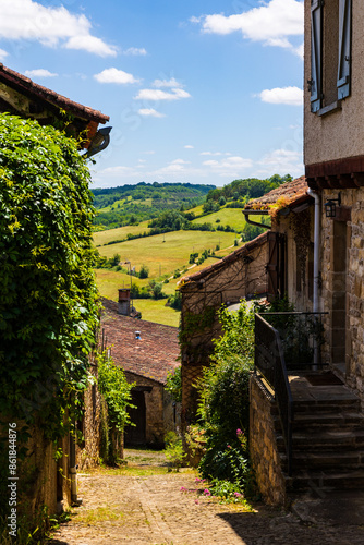 Vue à travers une ruelle du village médiéval de Cordes-sur-Ciel sur la compagne environnante photo