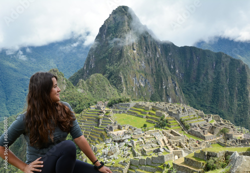 Fotografia Attractive young latina brunette woman with long hair observes the ruins of Machu Picchu sitting in peace and happy feeling the energy of this magical place in the world