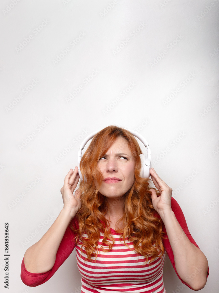 woman in her thirties with large headphones and a bewildered face woman in her thirties with large headphones and a bewildered face