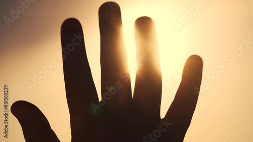 A girl in religion with her hands in the sun. Woman person happy concept. A girl glaring at the sun with her hands. A girl glaring at the sun with her hands in lifestyle religion.