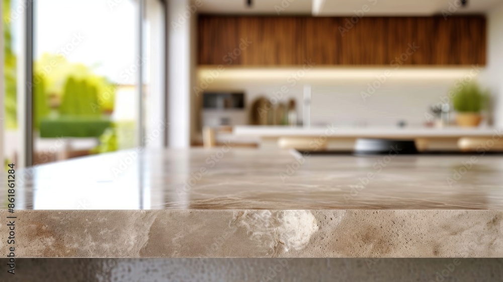 Close-up of a polished stone kitchen countertop in a modern home with a blurred background featuring wooden cabinets, large windows, and a view of greenery Close-up of a polished stone kitchen countertop in a modern home with a blurred background featuring wooden cabinets, large windows, and a view of greenery
