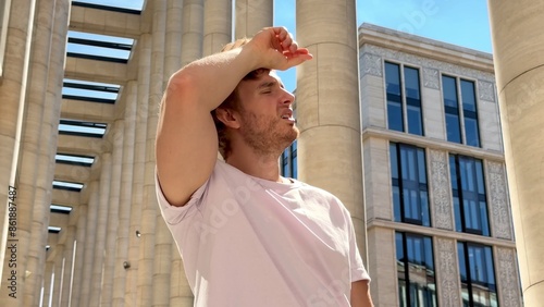 tired sick exhausted man is suffering from hot Summer heat stroke, sunshine, hot weather day, sweaty and thirsty, high temperature. Feeling unwell, unhealthy