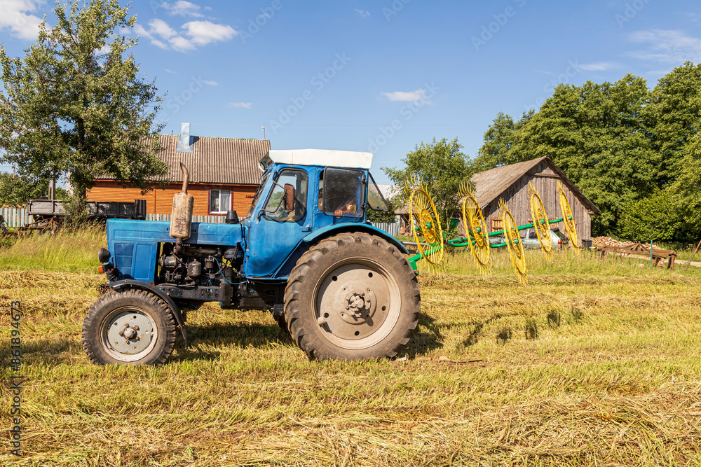 natural lighting. The driver of a blue tractor cleans hay and oats. close-up natural lighting. The driver of a blue tractor cleans hay and oats. close-up