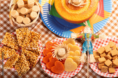 Festa Junina, beautiful rustic table with dishes containing various types of sweets for Festa Junina in Brazil, top view. photo