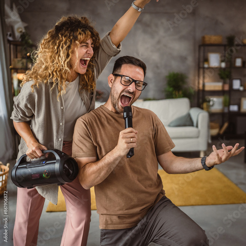 Boyfriend sing on microphone while girlfriend hold loudspeaker karaoke