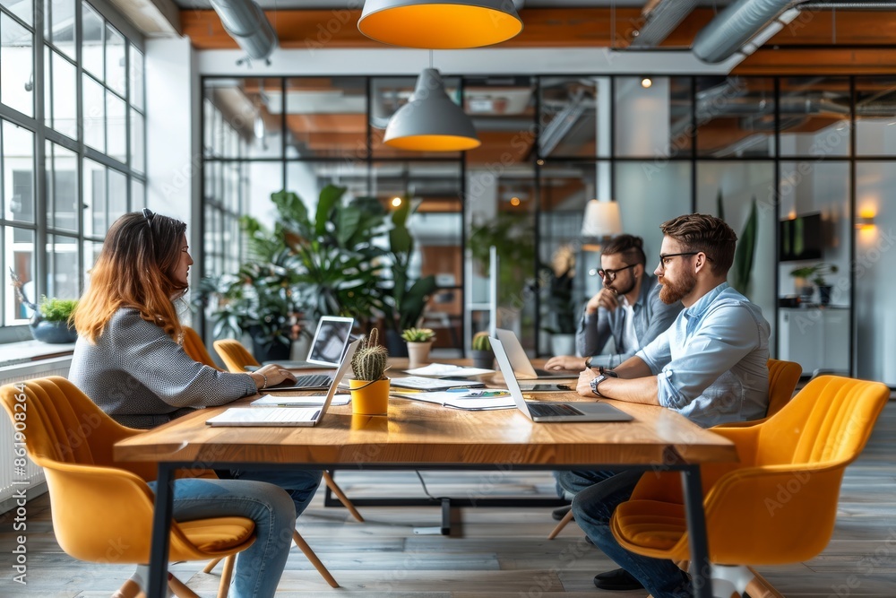 Modern Office Workers Collaborate Around a Table Modern Office Workers Collaborate Around a Table