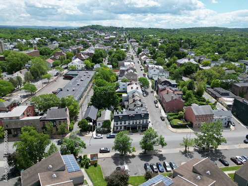 aerial view of hudson, new york (small hudson valley town city downtown historic district) mountains catskills ny travel destination main street with hills clouds cars tree matter
