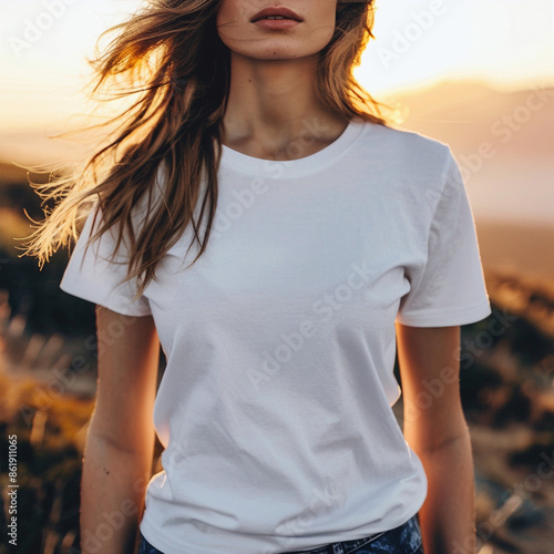 Model in anonymous white T-shirt, looking towards the camera and standing on the mountain. © PATRICIA