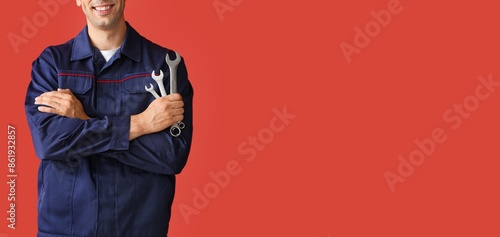 Male car mechanic on red ba...