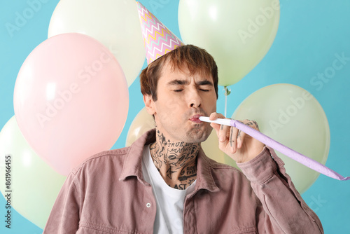 Young man with party whistl...