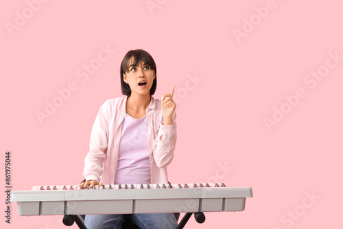 Young woman playing synthes...