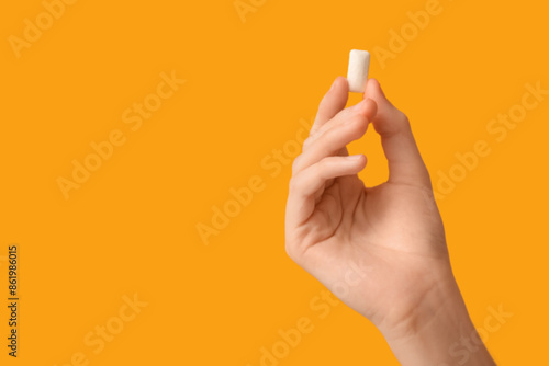 Foto Teenage girl with chewing gum on yellow background, closeup