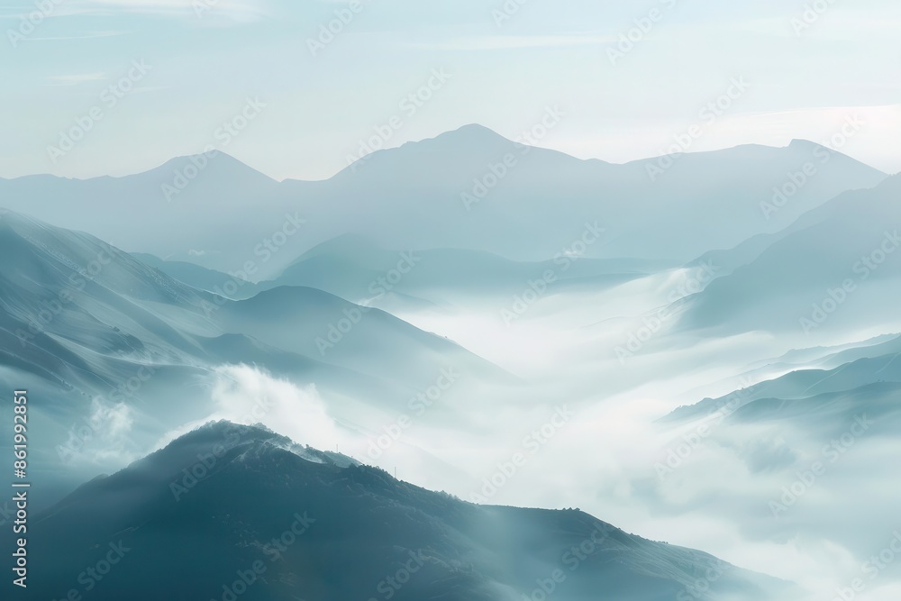 misty mountain panorama layered peaks shrouded in morning fog creating depth and mystery soft cool color palette enhances serene atmosphere