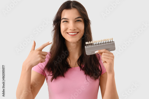 Smiling young woman pointin...