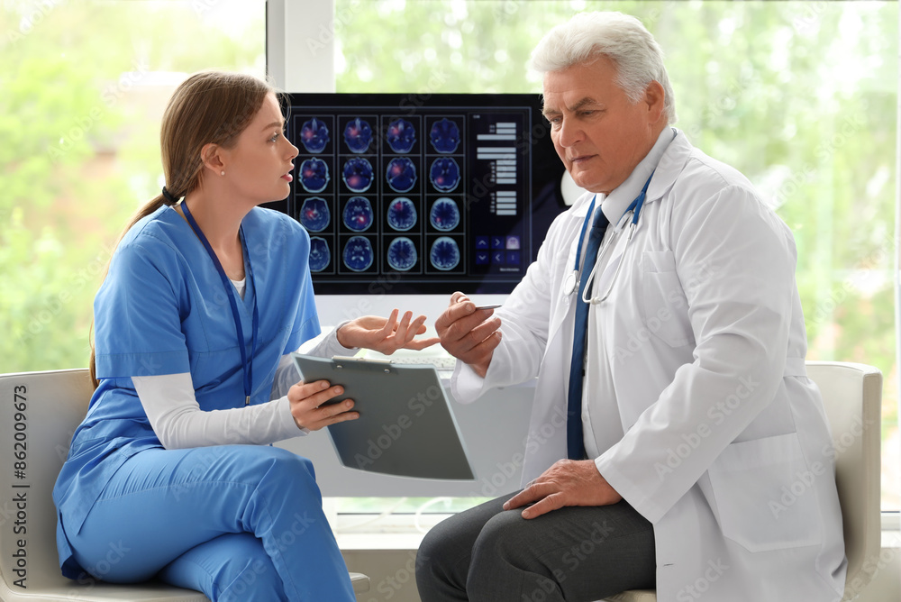 Fototapeta premium Mature doctor working with nurse in clinic