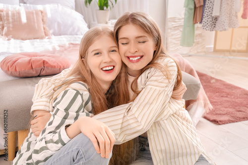 Happy young sisters embraci...