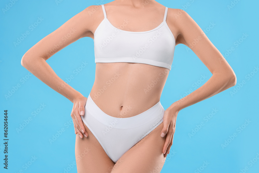 Diet and weight loss concept. Woman with slim body against light blue background, closeup Diet and weight loss concept. Woman with slim body against light blue background, closeup