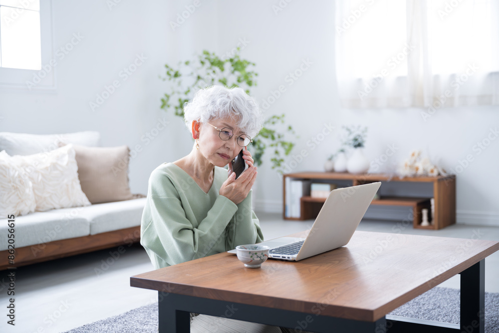 Senior woman talking on phone inquiry while looking at computer Negative image such as difficulty in cancellation Wide angle Senior woman talking on phone inquiry while looking at computer Negative image such as difficulty in cancellation Wide angle