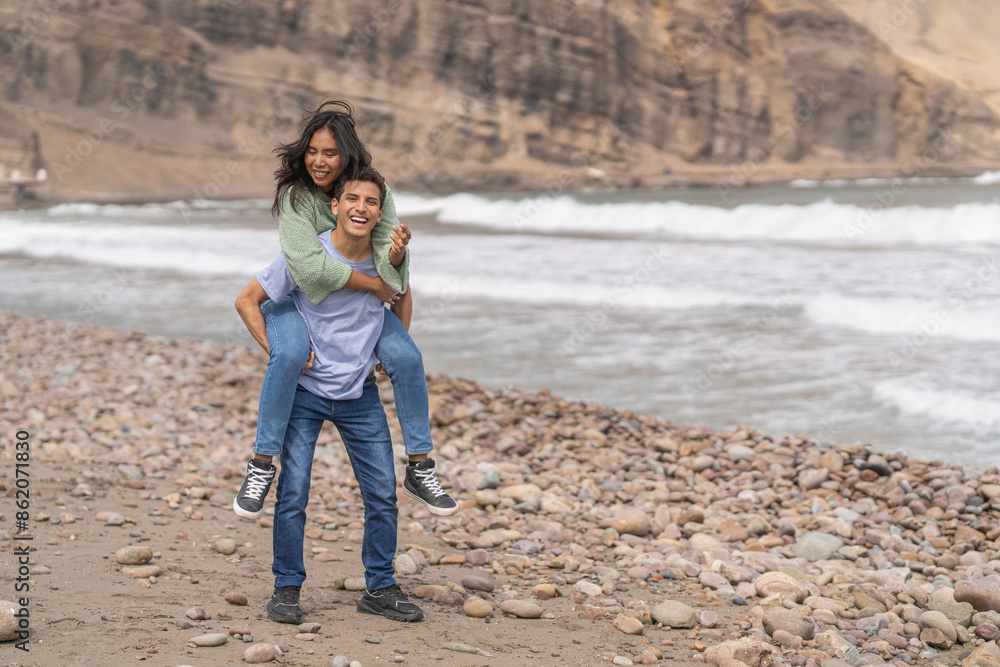 Woman piggybacking her boyfriend on the beach Woman piggybacking her boyfriend on the beach