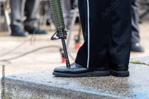 Obraz na płótnie A  military person stands at attention with his rifle pitched on the toe of his shinned boot