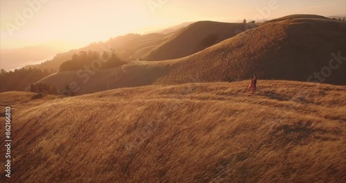 Male and female ballet dancer doing contempoary dance on dry grassy hills in Mt Tamalpais as sunset. San Francisco, California, United States of America. photo