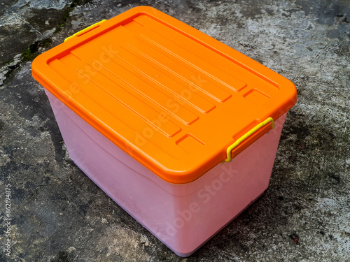 isolated Transparent plastic storage box or container, orange cover