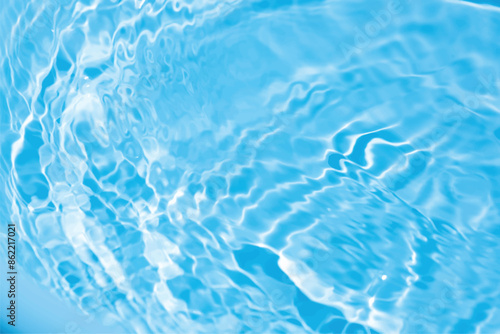 Blue water with ripples on the surface. Defocus blurred transparent blue colored clear calm water surface texture with splashes and bubbles. Water waves with shining pattern texture background.
