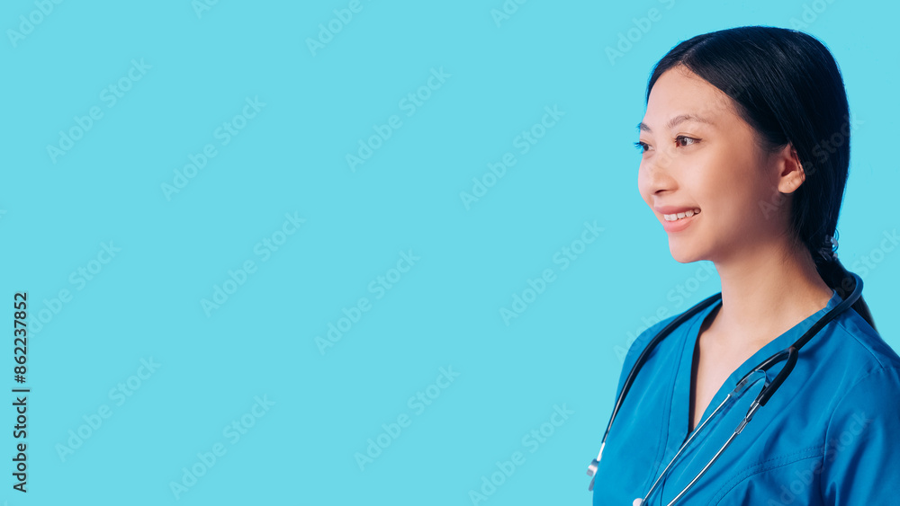Smiling doctor. Healthcare service. Medical employee. Friendly cheerful caring woman surgeon in hospital uniform isolated on blue empty space background.