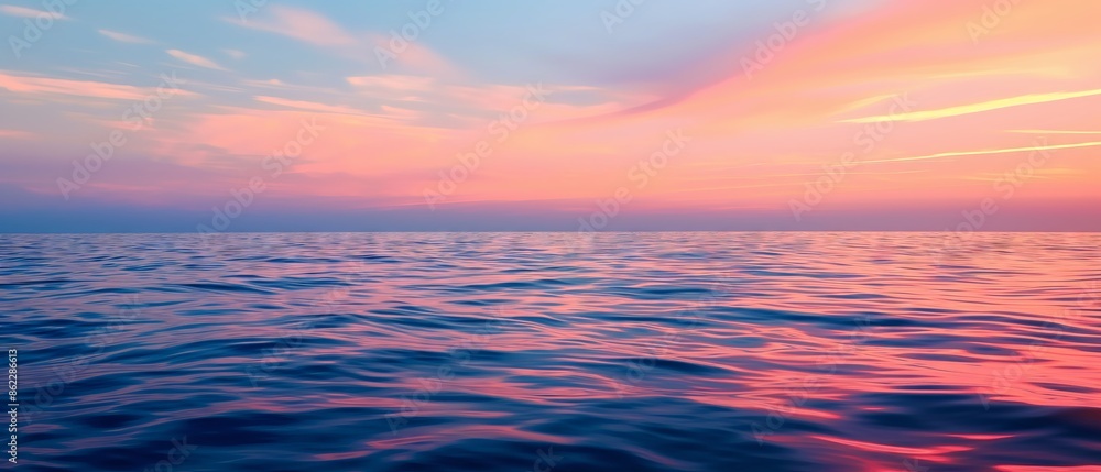 Sunset at sea: Orange-pink hues of the sunset, fading into the deep blue of the water and sky Sunset at sea: Orange-pink hues of the sunset, fading into the deep blue of the water and sky