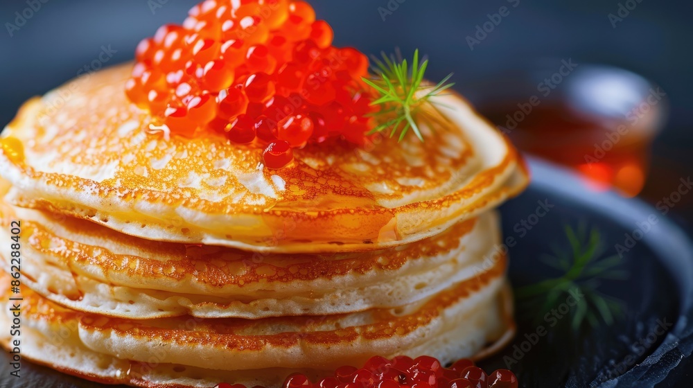 A stack of pancakes with red caviar on the table. A healthy breakfast. A delicious traditional dish on a dark background. A stack of pancakes with red caviar on the table. A healthy breakfast. A delicious traditional dish on a dark background.