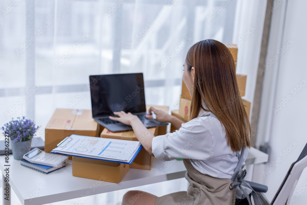 Beautiful Asian online business owner is preparing a parcel box to prepare the package for delivery to the customer asian Entrepreneur SME business concept. Beautiful Asian online business owner is preparing a parcel box to prepare the package for delivery to the customer asian Entrepreneur SME business concept.