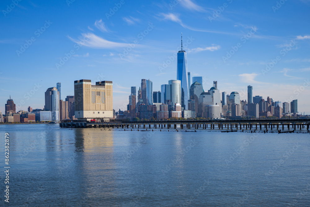 Fototapeta premium The city skyline of New York City in USA, United States. Blue sky day with iconic buildings. New York City NYC Manhattan Downtown Skyline, viewed from Jersey City, USA.