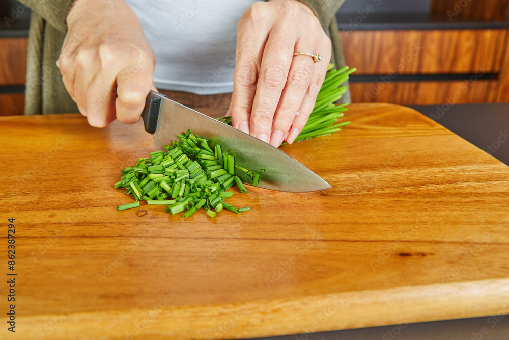 A home cook prepares fresh green onions for homemade creamy soup A home cook prepares fresh green onions for homemade creamy soup
