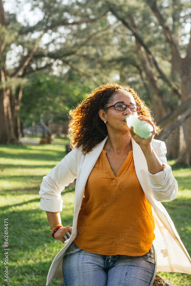 Fototapeta premium Afro-Latin woman with healthy lifestyle, enjoying a green drink