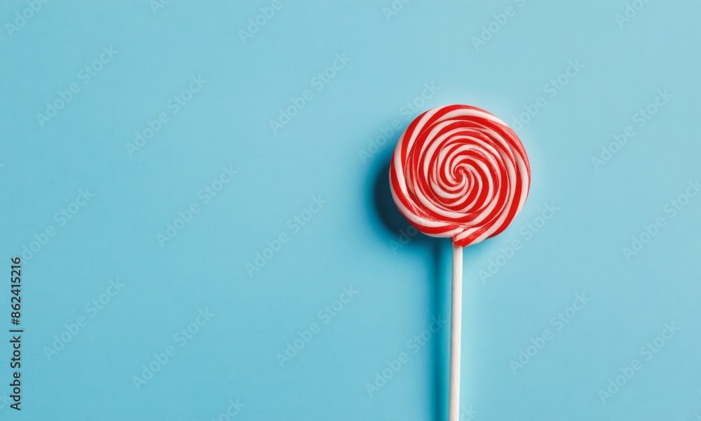 Lollipop with spiral design isolated on blue background Lollipop with spiral design isolated on blue background